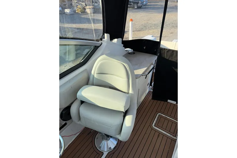 Slide: The Image of 2022 Boston Whaler 240 Vantage interior with cushioned seating and wood-style flooring. - 14