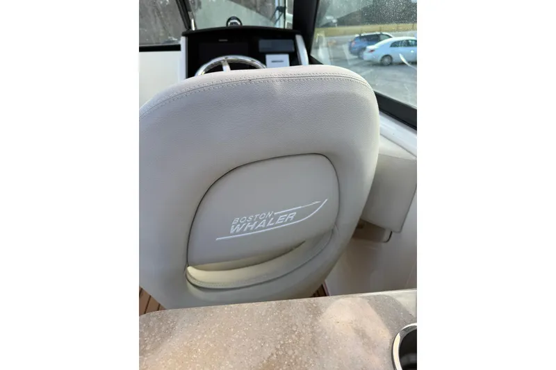 Slide: The Image of 2022 Boston Whaler 240 Vantage boat interior with branded seat and steering wheel. - 5