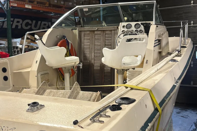 Slide: The Image of 1987 Sea Hawk 215 boat interior with dual white captain chairs and control panel. - 3