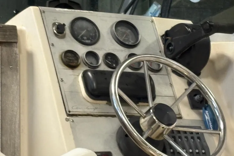 Slide: The Image of 1987 Sea Hawk 215 boat dashboard with steering wheel and gauges. - 6