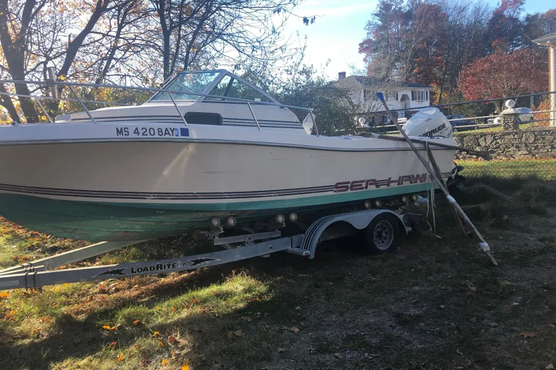 Slide: The Image of 1987 Sea Hawk 215 boat dashboard with steering wheel and gauges. - 7