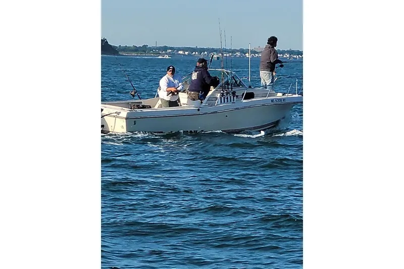 Slide: The Image of Three people fishing on a 1987 Sea Hawk 215 boat in open water. - 8