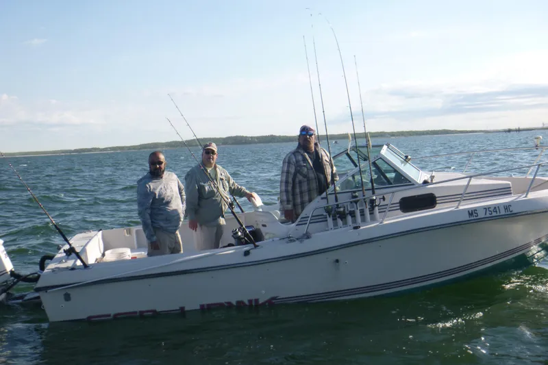 Slide: The Image of Three people on a 1987 Sea Hawk 215 boat, fishing on a sunny day. - 9