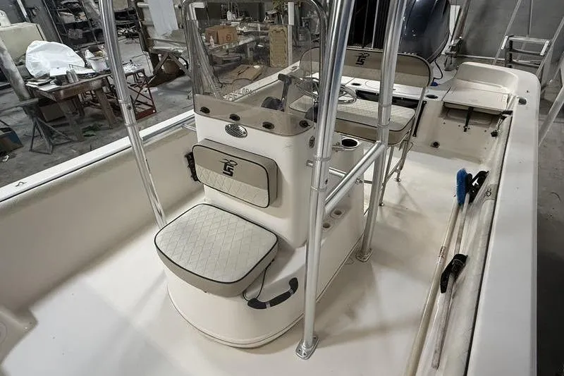 Slide: The Image of 2020 Carolina Skiff 21 LS boat interior with seating and console in a workshop setting. - 13