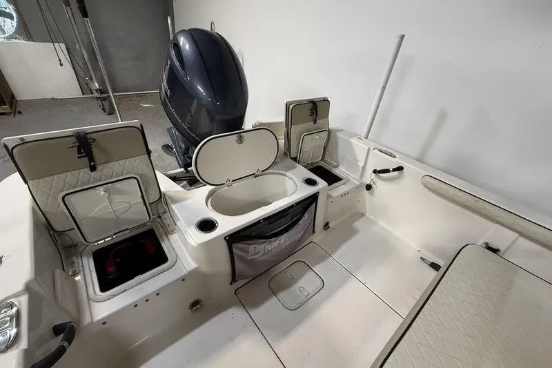 Slide: The Image of 2020 Carolina Skiff 21 LS boat interior with storage compartments and outboard motor. - 9
