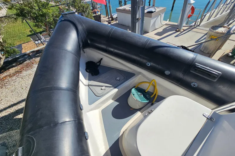 Slide: The Image of 2007 Ribcraft 6.5 inflatable boat interior with storage and equipment, docked by the water. - 20