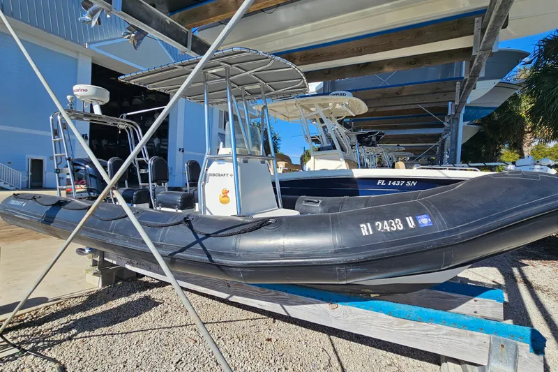 Slide: The Image of 2007 Ribcraft 6.5 inflatable boat on a trailer in a marina setting. - 5