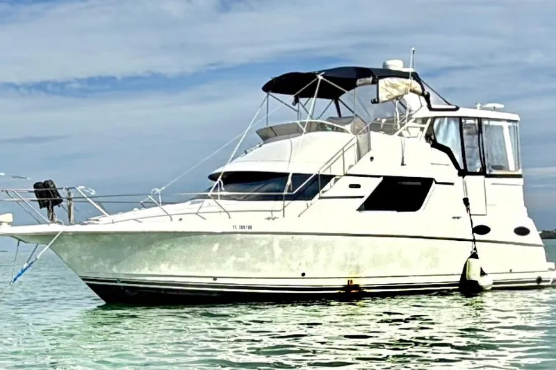 The Image of 1998 Silverton 40 Convertible yacht anchored on calm water under a clear sky. - 0