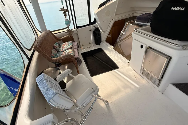 Slide: The Image of 1998 Silverton 40 Convertible boat interior with seating and kitchenette, overlooking clear water. - 22