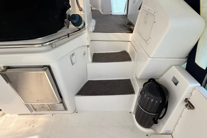Slide: The Image of Interior steps of a 1998 Silverton 40 Convertible yacht with carpeted stairs and stainless steel railing. - 23