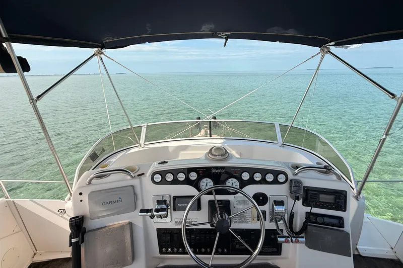 Slide: The Image of 1998 Silverton 40 Convertible yacht helm with ocean view, featuring Garmin navigation system. - 27