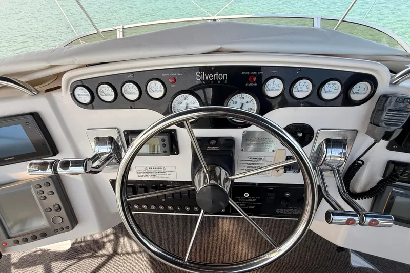 Slide: The Image of 1998 Silverton 40 Convertible yacht helm with steering wheel and control panel. - 32