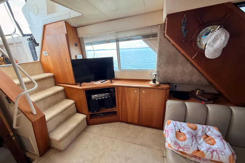 Slide: The Image of Interior of 1998 Silverton 40 Convertible yacht with TV, stairs, and ocean view. - 44