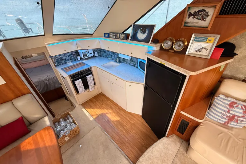 Slide: The Image of 1998 Silverton 40 Convertible yacht interior with modern kitchen, cozy seating, and nautical decor. - 48