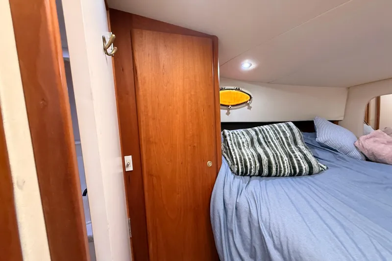 Slide: The Image of 1998 Silverton 40 Convertible cabin with cozy bed and wooden door. - 57