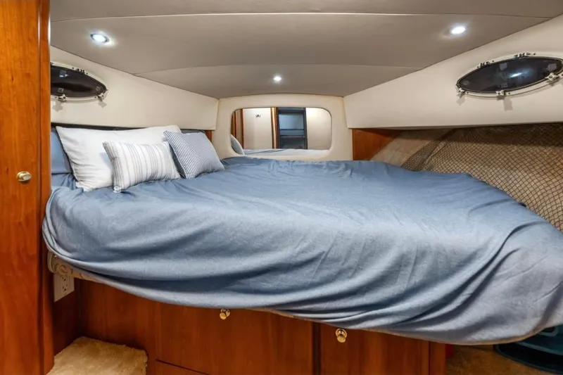 Slide: The Image of Cozy bedroom interior of 1998 Silverton 372 Motor Yacht with blue bedding and portholes. - 58