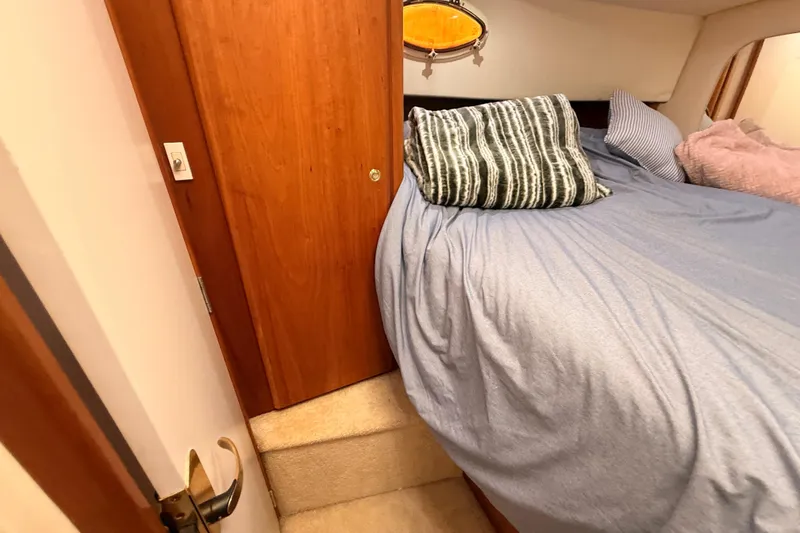 Slide: The Image of Cozy bedroom interior of 1998 Silverton 40 Convertible yacht with plush bedding. - 59