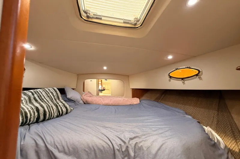 Slide: The Image of 1998 Silverton 40 Convertible cabin interior with cozy bedding and porthole window. - 61
