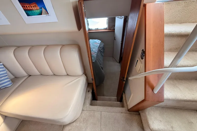 Slide: The Image of 1998 Silverton 40 Convertible interior with beige seating, stairs, and cabin entrance. - 68