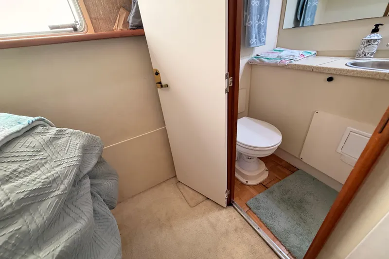 Slide: The Image of 1998 Silverton 40 Convertible yacht bathroom with toilet, sink, and cozy interior. - 71
