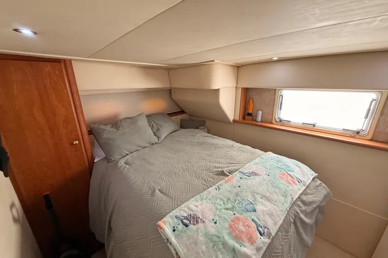 Slide: The Image of Cozy bedroom interior of 1998 Silverton 40 Convertible yacht with window and wooden accents. - 72
