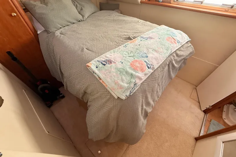 Slide: The Image of Cozy bedroom interior of 1998 Silverton 40 Convertible yacht with neatly made bed. - 73