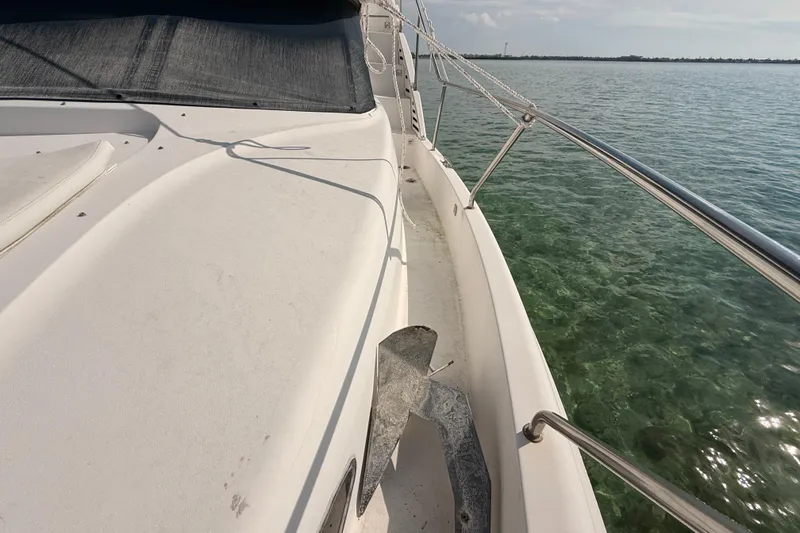 Slide: The Image of 1998 Silverton 40 Convertible yacht deck with anchor, overlooking clear water. - 75