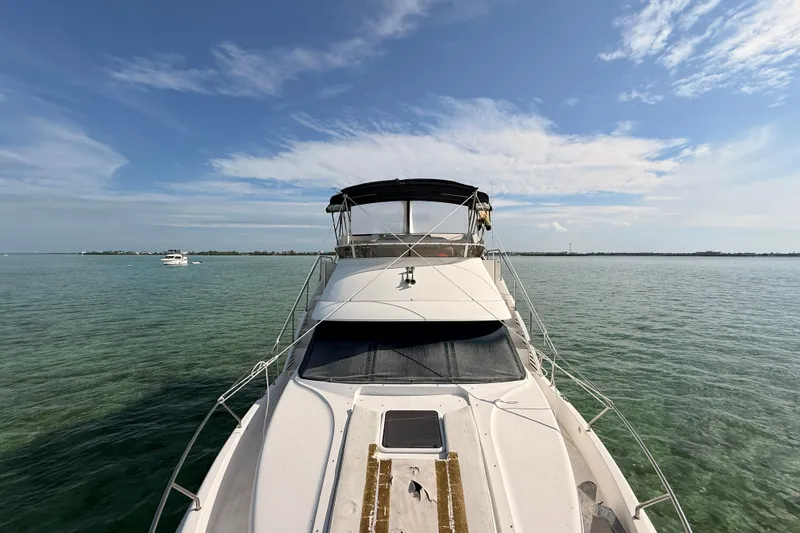Slide: The Image of 1998 Silverton 40 Convertible yacht on calm waters under a clear blue sky. - 77