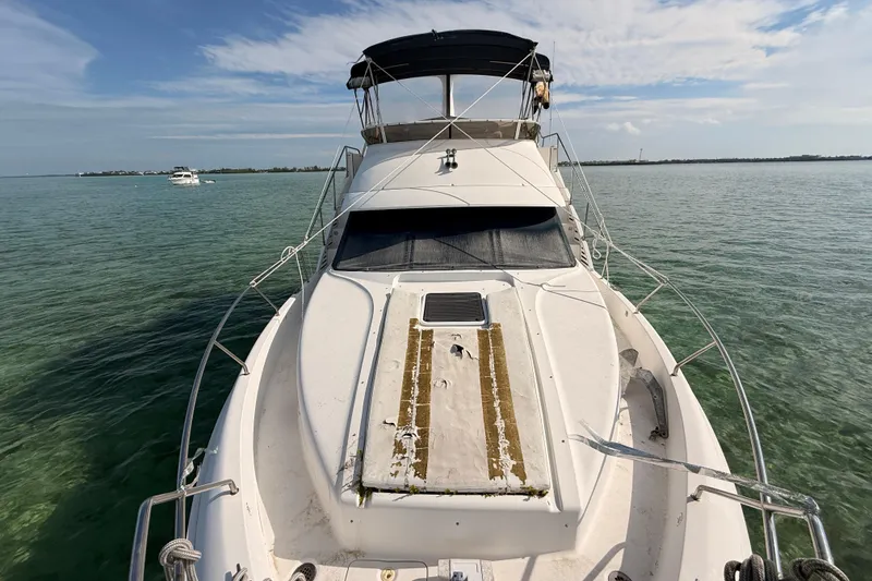 Slide: The Image of 1998 Silverton 40 Convertible yacht on calm waters under a clear sky. - 78