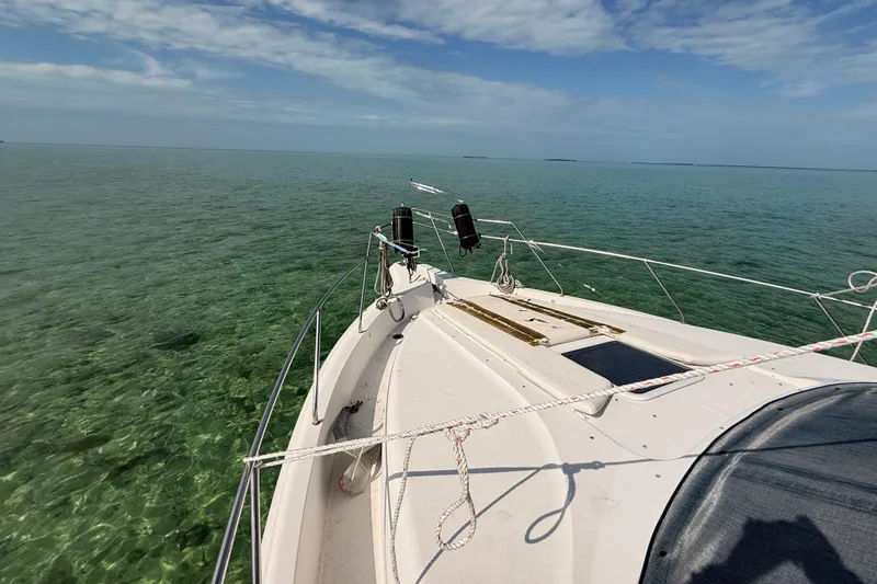 Slide: The Image of 1998 Silverton 40 Convertible boat cruising on clear turquoise waters under a blue sky. - 80