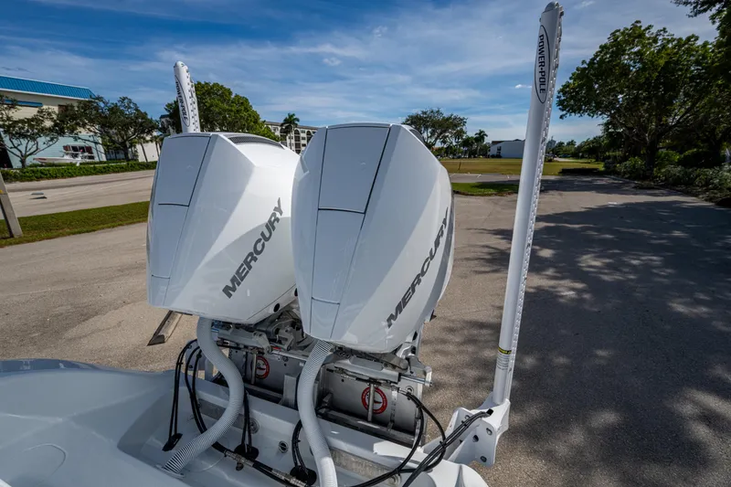 Slide: The Image of Twin Mercury engines on a 2026 Yellowfin 26 Hybrid boat, parked outdoors. - 11
