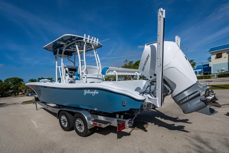 Slide: The Image of 2026 Yellowfin 26 Hybrid boat with Mercury engine on trailer, parked outdoors. - 35
