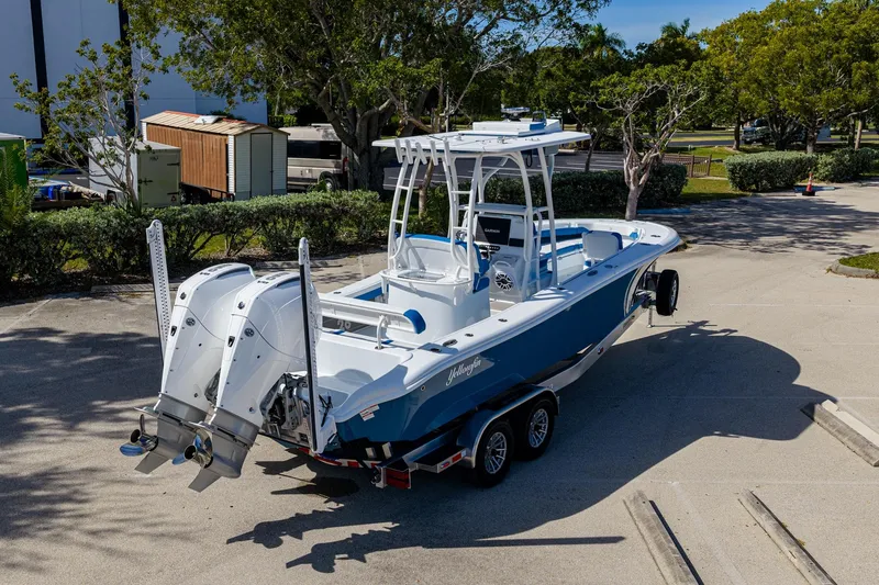 Slide: The Image of 2026 Yellowfin 26 Hybrid boat on trailer, featuring dual outboard engines, parked outdoors. - 39