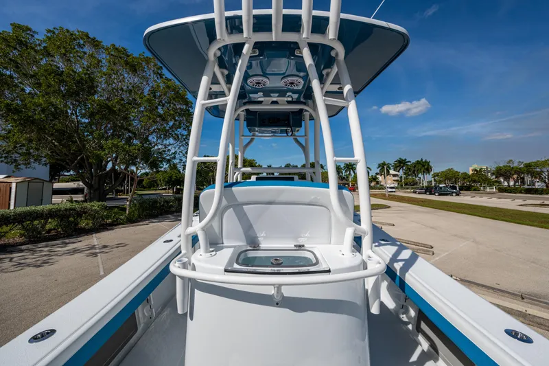 Slide: The Image of 2026 Yellowfin 26 Hybrid boat with T-top, parked outdoors under clear blue sky. - 42