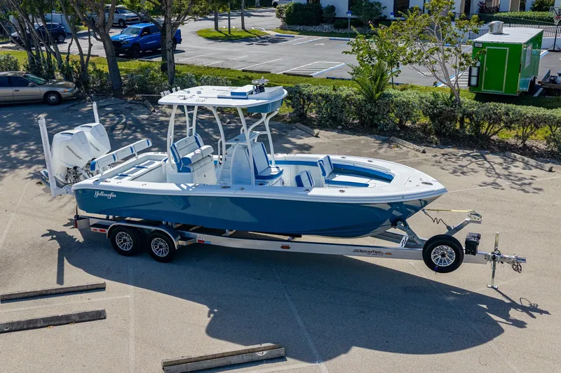 Slide: The Image of 2026 Yellowfin 26 Hybrid boat on trailer in parking lot, featuring sleek design and dual engines. - 48