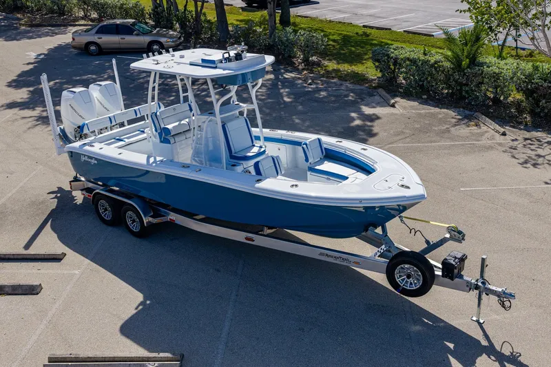 Slide: The Image of 2026 Yellowfin 26 Hybrid boat on trailer in parking lot, blue and white design. - 50