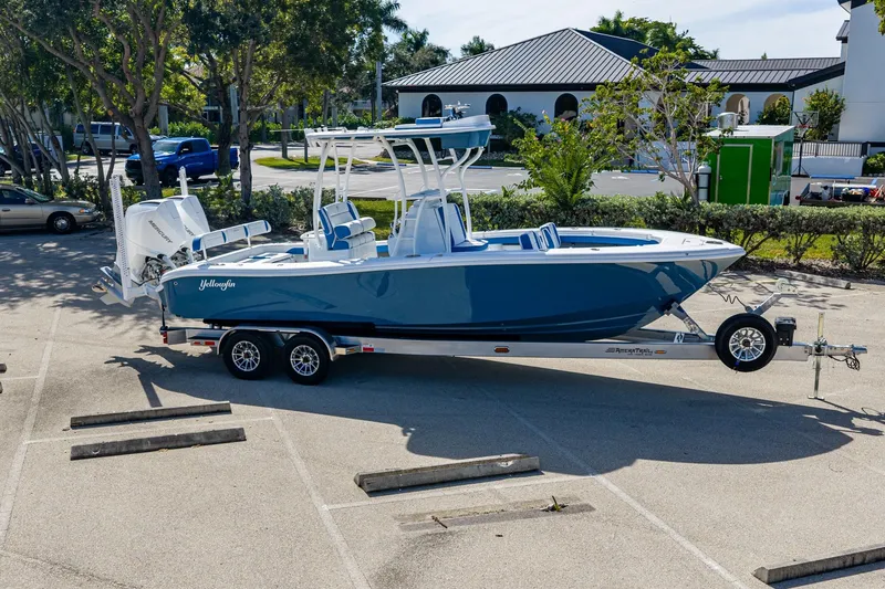 Slide: The Image of 2026 Yellowfin 26 Hybrid boat on trailer in parking lot, surrounded by trees and vehicles. - 51