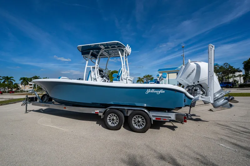 Slide: The Image of 2026 Yellowfin 26 Hybrid boat on trailer, parked under clear blue sky. - 53