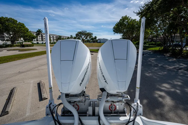 Slide: The Image of 2026 Yellowfin 26 Hybrid boat with dual Mercury outboard engines in a sunny parking area. - 9