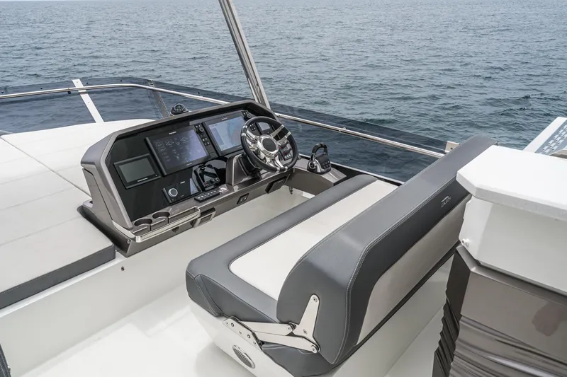 Slide: The Image of 2023 Galeon 640 Fly yacht helm with modern controls and ocean view. - 12