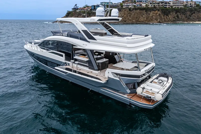 Slide: The Image of Luxury 2023 Galeon 640 Fly yacht cruising near scenic coastline. - 2