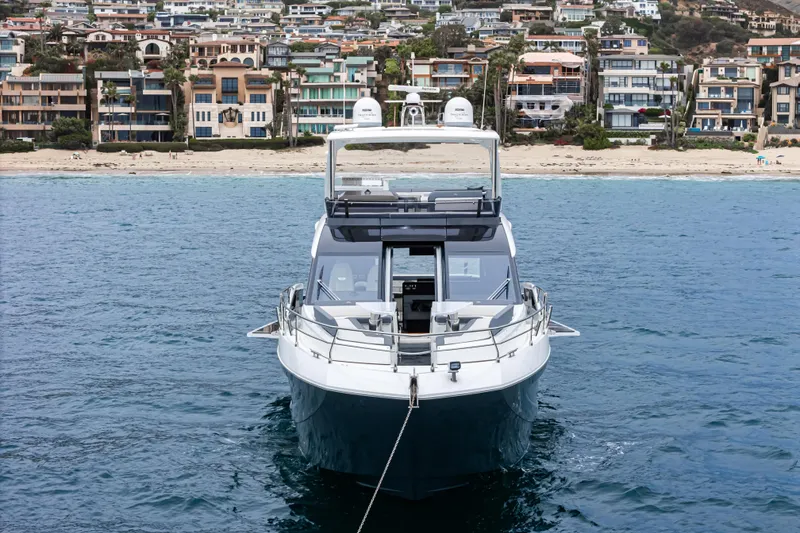 Slide: The Image of 2023 Galeon 640 Fly yacht anchored near a scenic coastal town. - 58