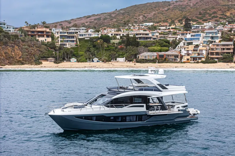 Slide: The Image of 2023 Galeon 640 Fly yacht cruising near scenic coastal homes. - 59