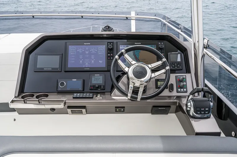 Slide: The Image of 2023 Galeon 640 Fly yacht helm with advanced navigation controls and sleek steering wheel. - 64
