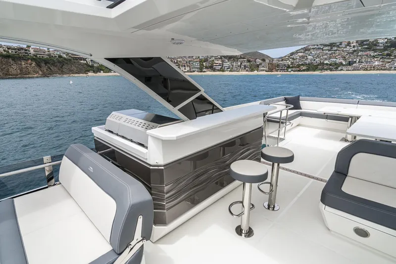 Slide: The Image of Luxurious 2023 Galeon 640 Fly yacht deck with bar and seating, overlooking scenic coastline. - 67