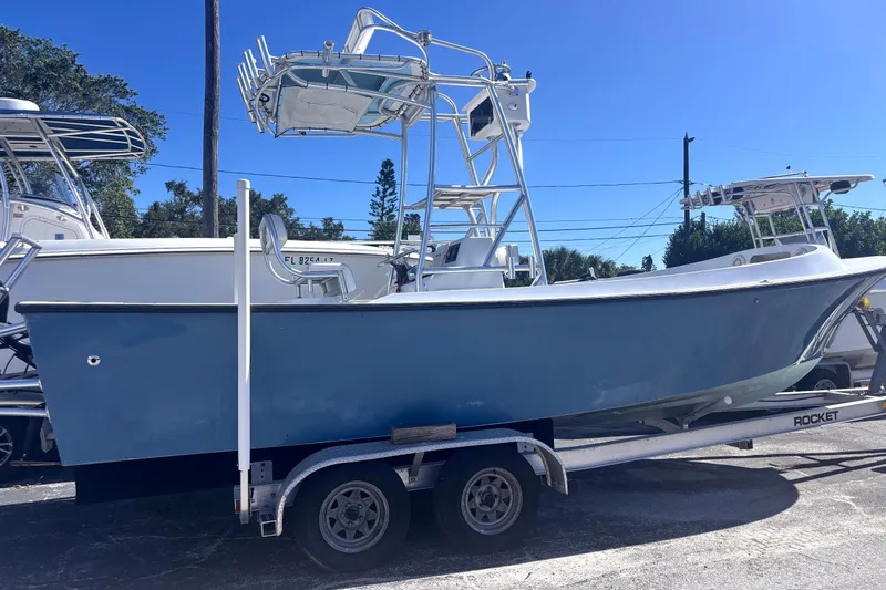 Slide: The Image of 1974 Aquasport 2400 Center Console boat on trailer, blue hull, sunny day. - 3
