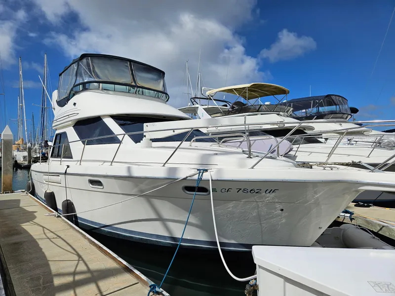 The Image of 1997 Bayliner 3788 Command Bridge Motoryacht docked at marina under blue sky. - 0