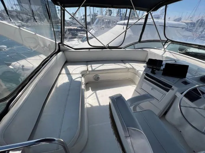 Slide: The Image of 1997 Bayliner 3788 Command Bridge Motoryacht interior with seating and helm, docked at marina. - 11