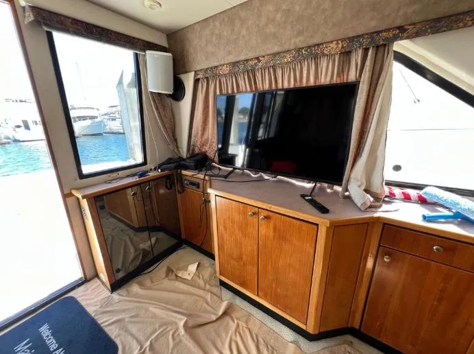 Slide: The Image of Interior of 1997 Bayliner 3788 Command Bridge Motoryacht with TV and wooden cabinetry. - 16