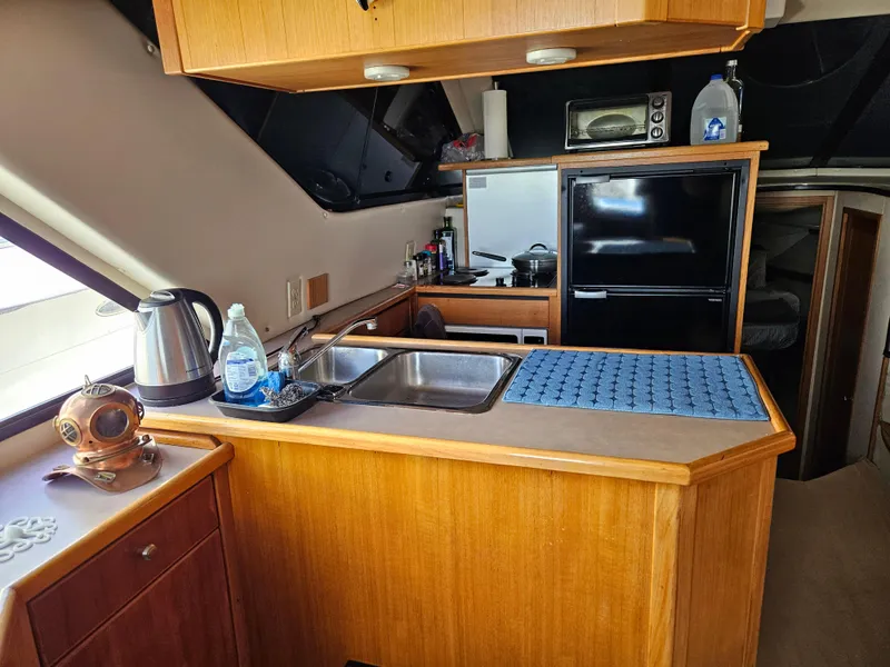 Slide: The Image of 1997 Bayliner 3788 Command Bridge Motoryacht kitchen with sink, fridge, and appliances. - 18